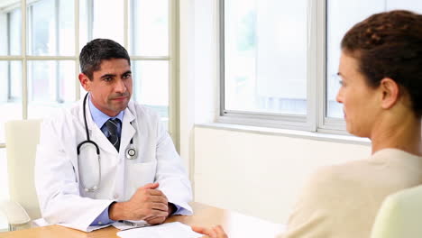 Doctor-speaking-with-his-sick-patient-at-desk