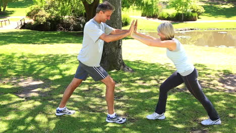 Couple-leaning-against-each-other-to-stretch-in-the-park