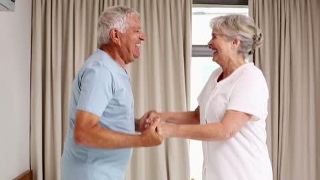 Senior-couple-jumping-on-the-bed