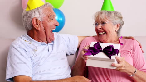 Senior-couple-celebrating-a-birthday-on-the-couch