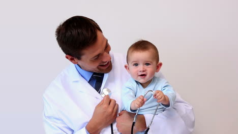Handsome-pediatrician-holding-baby-boy