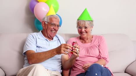 Senior-couple-celebrating-a-birthday-on-the-couch