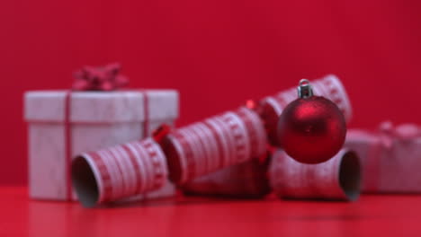 Christmas-bauble-dropping-and-bouncing-beside-crackers-and-presents