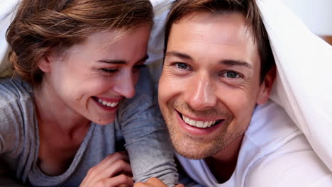 Happy-couple-lying-under-the-duvet