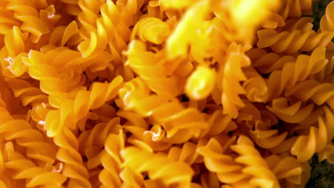 Fusilli-pasta-pouring-onto-more