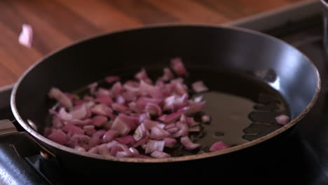 Onions-being-dropped-into-a-frying-pan