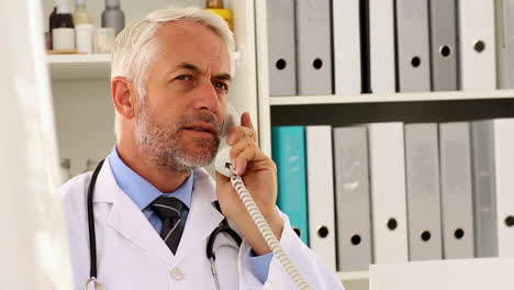 Doctor-talking-on-the-phone-at-his-desk