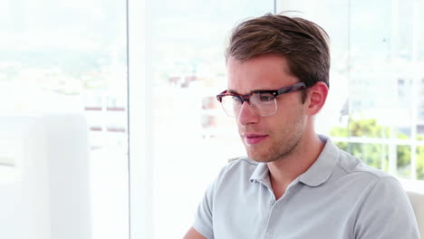 Casual-businessman-working-at-his-desk