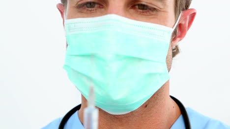 Handsome-nurse-preparing-a-syringe