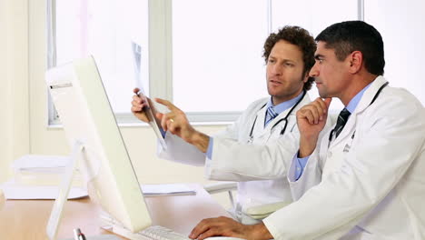 Doctors-sitting-at-desk-talking-about-xray