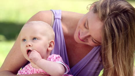 Happy-mother-playing-with-her-baby-girl-in-the-park