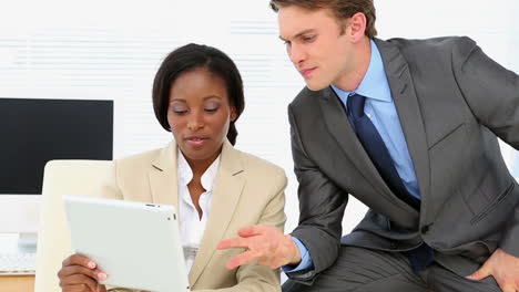 Business-people-talking-together-at-desk-with-tablet