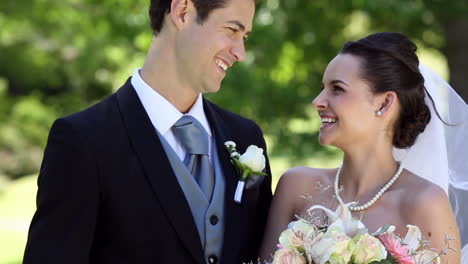 Happy-newlyweds-standing-beside-their-wedding-cake-