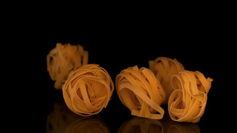 Tagliatelle-pouring-onto-black-surface