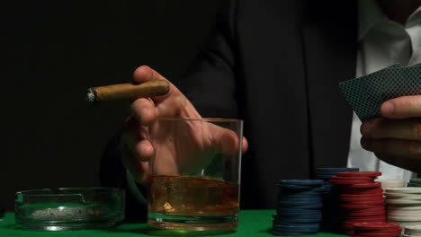 Cool-gambler-picking-up-his-glass-of-whiskey