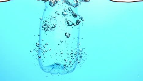 Flasche-Fällt-Ins-Blaue-Wasser