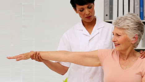 Nurse-showing-elderly-patient-how-to-exercise-her-injured-arm