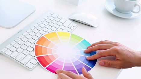Graphic-designer-using-colour-wheel-at-his-desk