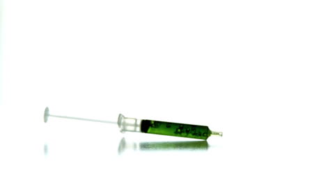 Syringe-with-green-liquid-falling