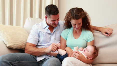 Happy-couple-on-the-couch-with-their-baby-son