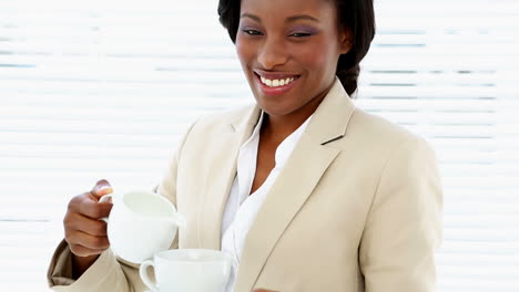 Businesswoman-pouring-milk-into-her-cup