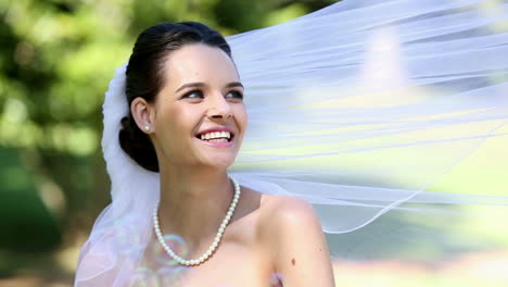 Beautiful-bride-smiling-at-camera-in-the-park