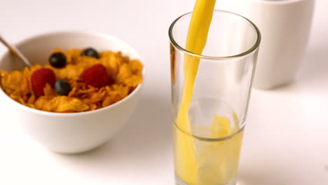 Orange-juice-pouring-into-glass-at-breakfast-table