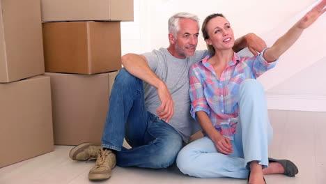 Couple-sitting-beside-cardboard-boxes-and-chatting