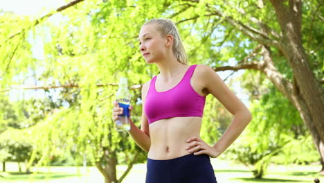 Fit-blonde-drinking-water-in-the-park