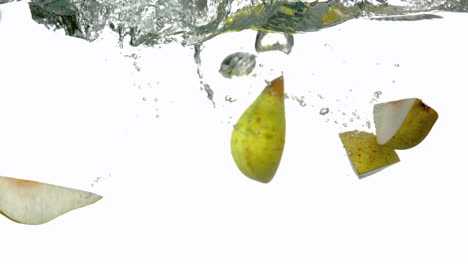 Pear-segments-plunging-into-water-on-white-background
