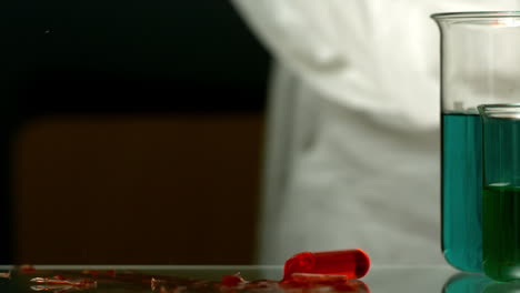 Test-tube-of-red-chemical-falling-and-smashing