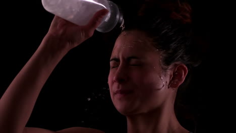 Woman-spraying-herself-with-water-after-workout