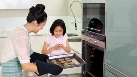 Mother-taking-baking-tray-out-of-oven