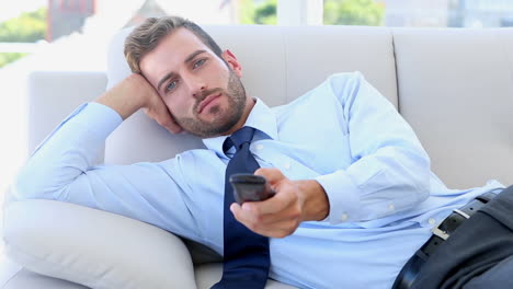 Businessman-sitting-on-couch-watching-tv