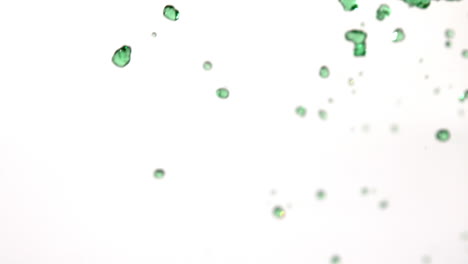 Green-water-raining-across-white-background