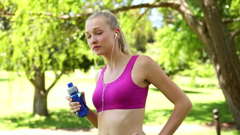Fit-blonde-drinking-water-in-the-park-on-her-jog