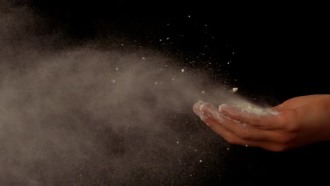 Flour-blowing-out-of-womans-hands