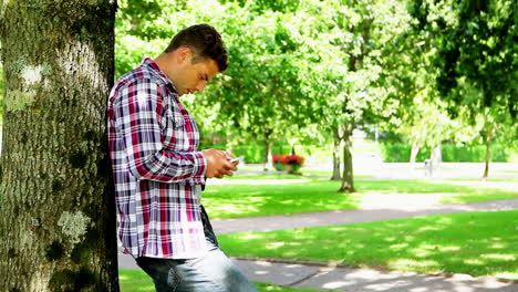 Joven-Estudiante-Usando-Su-Teléfono-Inteligente-Afuera