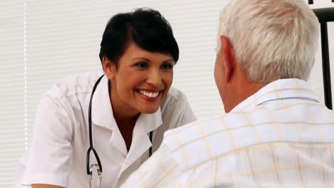 Nurse-talking-with-elderly-patient-in-a-wheelchair