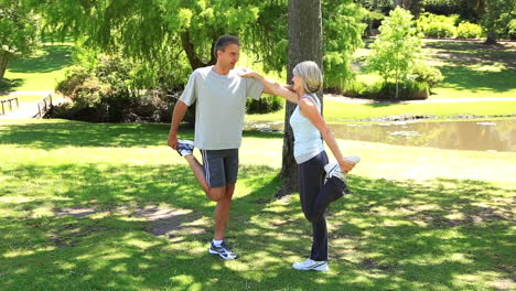 Couple-stretching-together-in-the-park