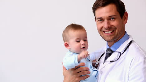 Handsome-pediatrician-holding-baby-boy