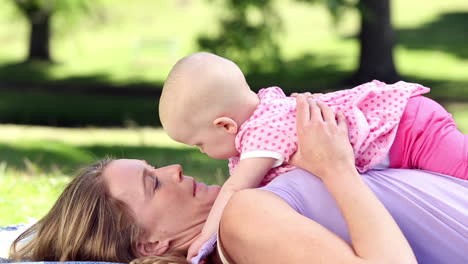 Happy-mother-playing-with-her-baby-girl-in-the-park