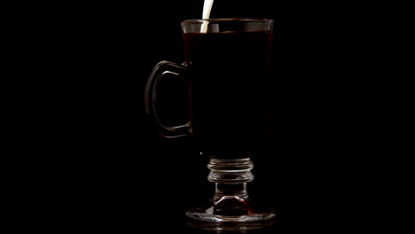 Milk-pouring-into-coffee-in-a-glass