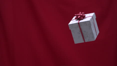 Weihnachtsgeschenk-In-Die-Luft-Geworfen-Roter-Hintergrund