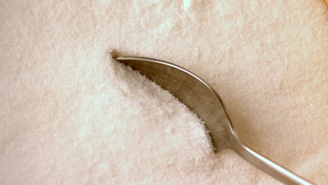 Teaspoon-scooping-up-white-sugar