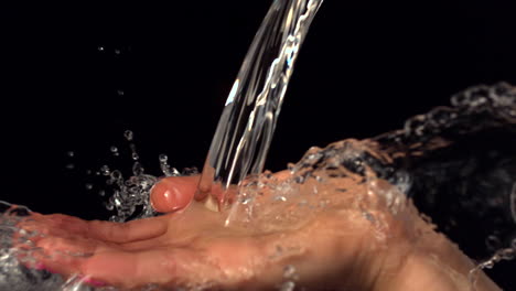 Agua-Cayendo-Sobre-La-Mano-Femenina