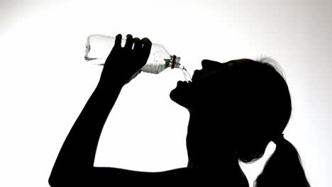 Silhouette-Einer-Frau,-Die-Aus-Einer-Flasche-Trinkt