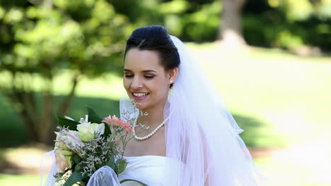 Beautiful-bride-smiling-at-camera-in-the-park