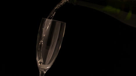 Champagne-pouring-into-flute-on-black-background