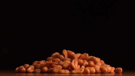 Peanuts-pouring-on-black-background